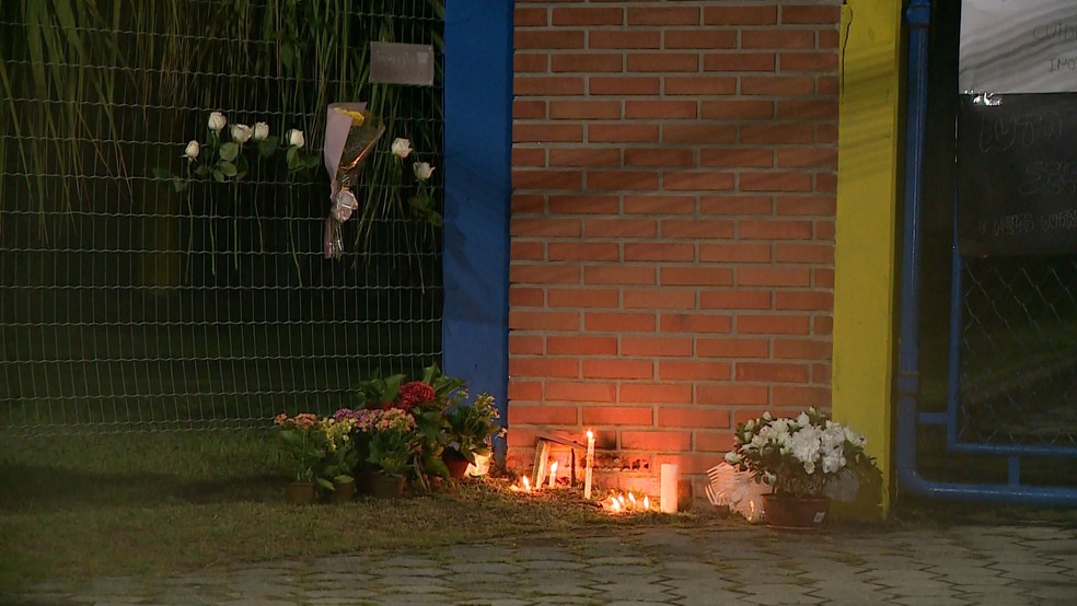 Populares deixaram flores, acenderam velas e colaram cartazes na fachada de escola em homenagem a vítimas dos ataques em Aracruz — Foto: Reprodução/TV Gazeta