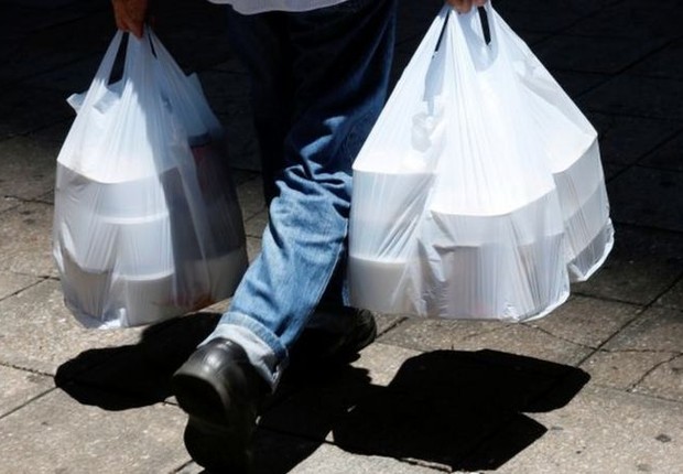 BBC: Homem buscando comida em meio à pandemia; delivery, comércio eletrônico e materiais hospitalares descartáveis fizeram uso de plástico explodir (Foto: REUTERS VIA BBC)