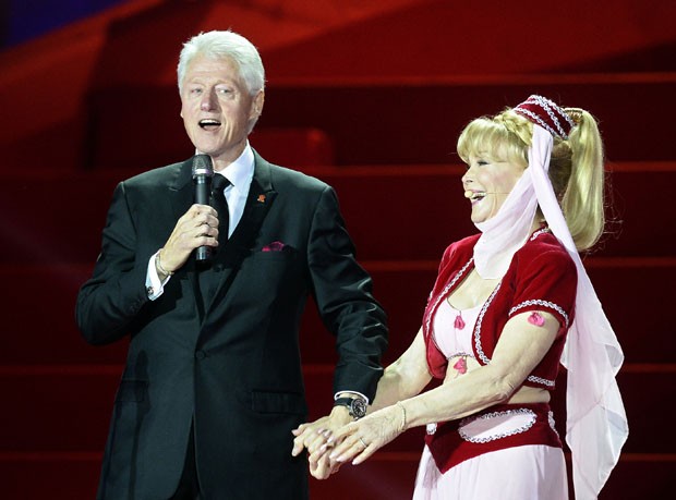 O ex-presidente Bill Clinton discursa ao lado de Barbara Eden, atriz conhecida por seu papel na série 'Jeannie é um Gênio' (Foto: Hans Punz/AP)