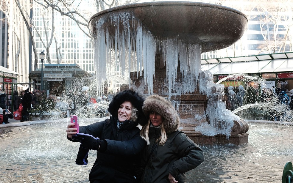 Turistas em Nova York aproveitaram para tirar fotos em frente a uma fonte congelada no Bryant Park (Foto: Spencer Platt/Getty Images North America/AFP)
