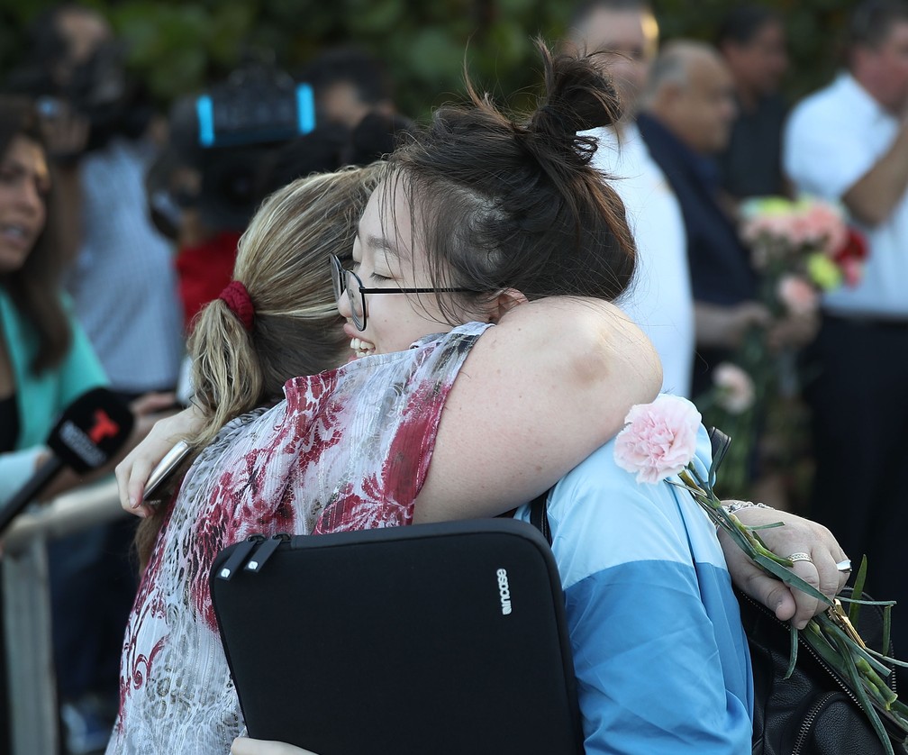 Estudante recebe abraço durante retorno às aulas em escola que foi alvo de ataque na Flórida (Foto: JOE RAEDLE / GETTY IMAGES NORTH AMERICA / AFP)