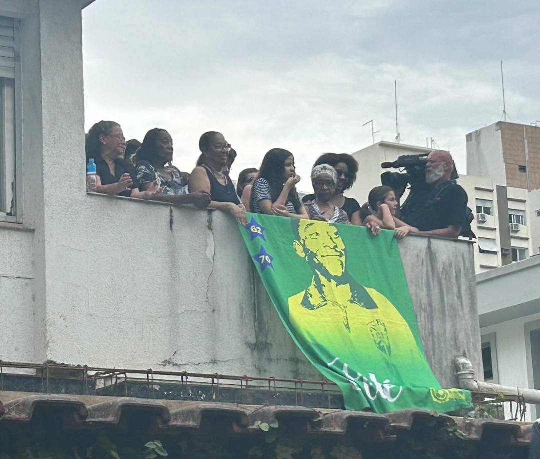 Familiares de Pelé aguardam passagem de cortejo na sacada da casa onde moram em Santos, no litoral de SP, nesta terça-feira (3).