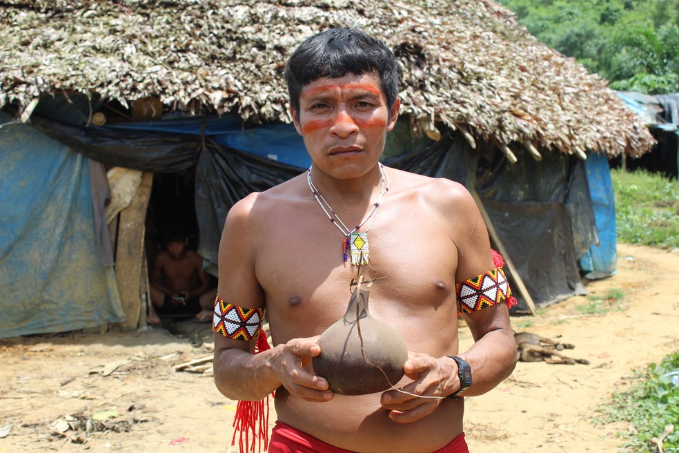 Líder indígena da comunidade Xaruna, Pedrinho Yanomami, segura urna funerária com as cinzas de uma criança — Foto: Valéria Oliveira/g1