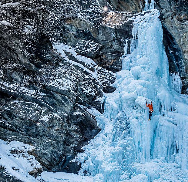 Alpinista escala cachoeira congelada. A iluminação é artificial, feita com potentes lanternas e flashes (Foto: Reprodução/Kamil Tamiola )