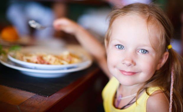 Criança comendo e sorrindo (Foto: Shutterstock)