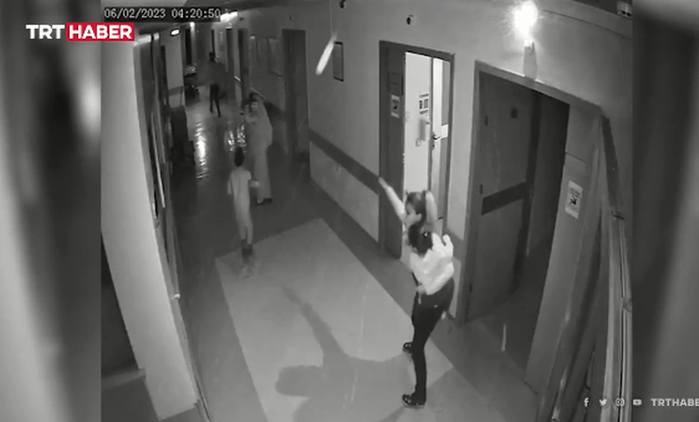 Seyma com uma criança nos braços enquanto evacua os quartis — Foto: Reprodução/TRTHABER