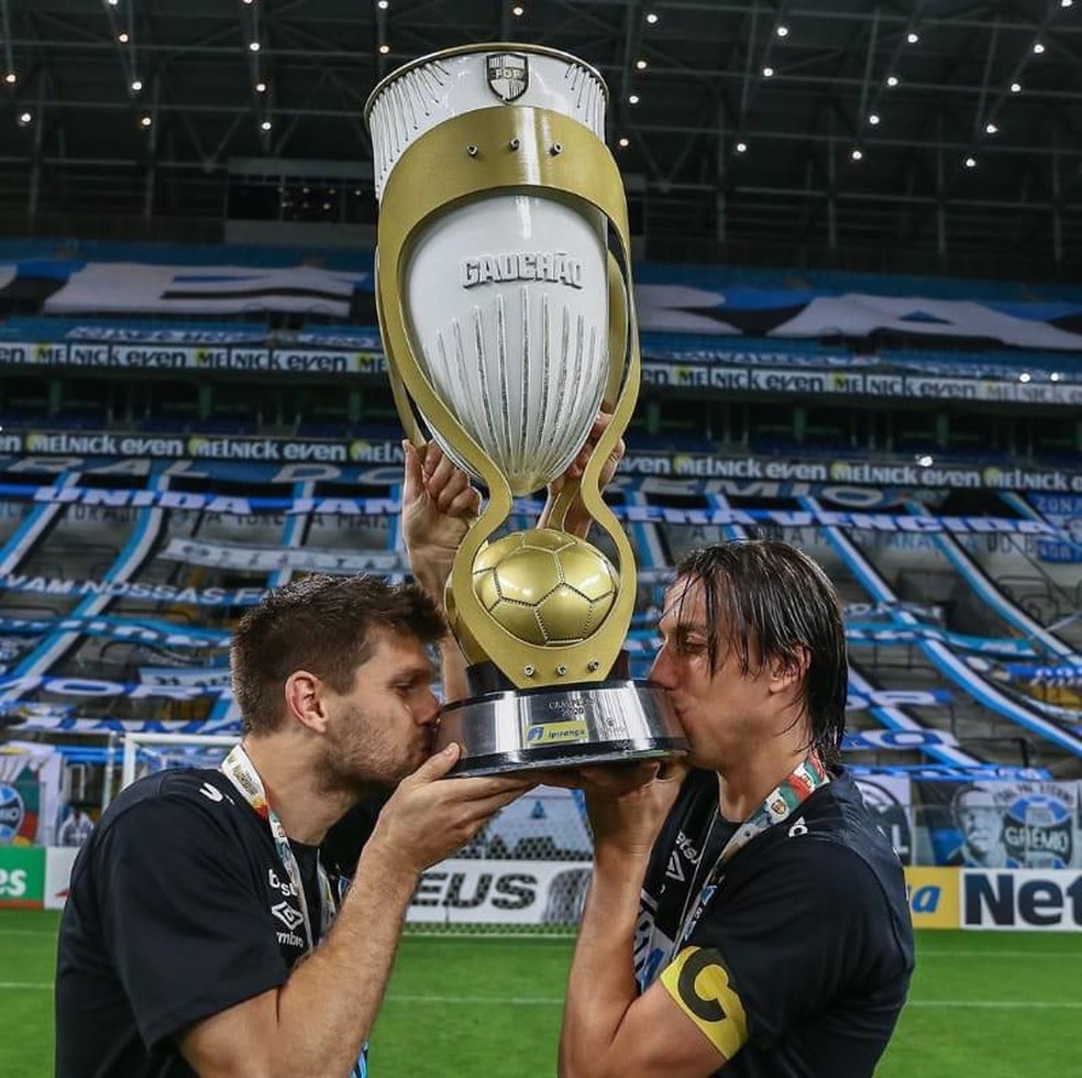 Kannemann junto com Geromel beijando a taça de campeão gaúcho em 2020 — Foto: Grêmio/Divulgação