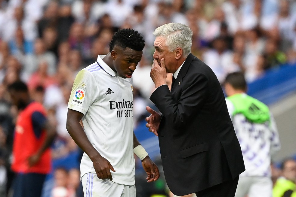 Vinicius Junior e Carlo Ancelotti conversam em partida do Real Madrid — Foto: Pierre-Philippe Marcou/AFP