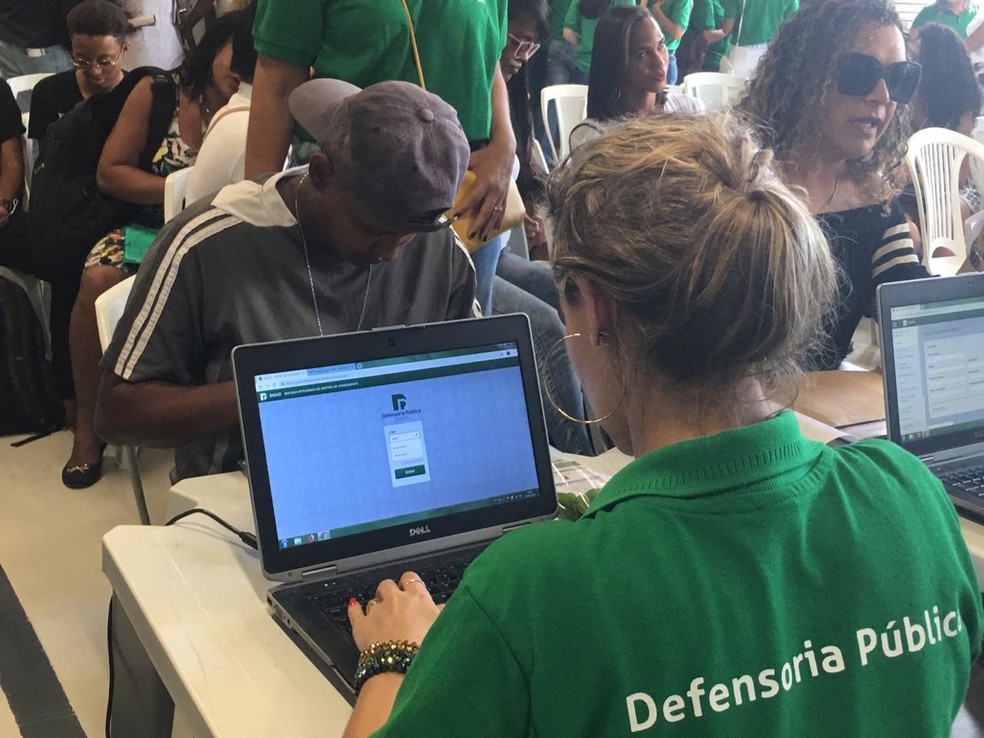 Atendimentos começaram por volta de 11h e seguem até 13h. Os interessados devem levar o máximo de documento possível para conseguir uma declaração que autoriza a retificação no cartório responsável.  — Foto: Phael Fernandes / G1