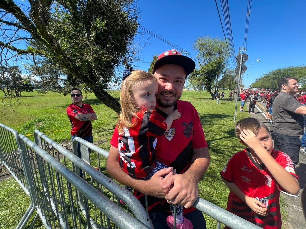 Pai e filha na expectativa da chegada do ônibus do Furacão  — Foto: André Ribas