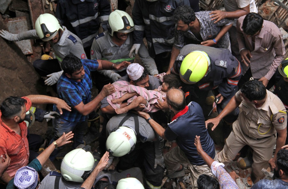 Criança foi resgatada dos escombros de prédio que desmoronou em Mumbai, na Índia, nesta terça-feira (16)  — Foto: Reuters