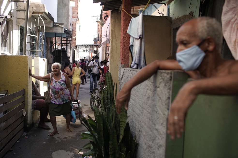 Homem usa máscara em comunidade no Rio de Janeiro em meio à pandemia de coronavírus, em maio. — Foto: AP Photo/Silvia Izquierdo