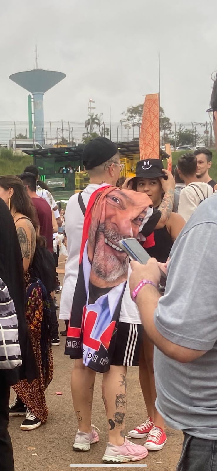 Enquanto espera o próximo show, fã posa com bandeira do ex-presidente Lula no festival (Foto: Ana Gonçalves / GQ Brasil)