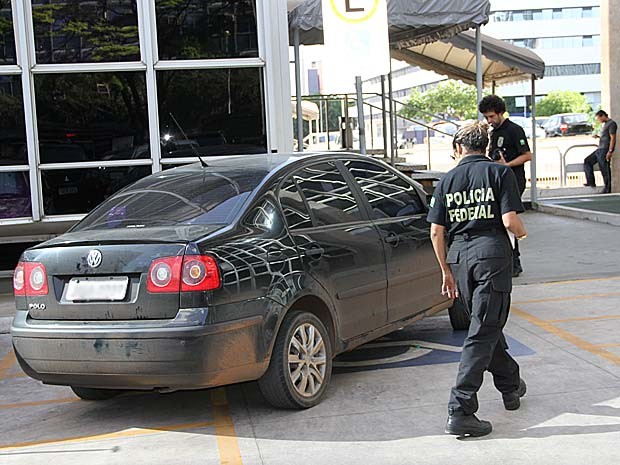 Policiais federais em volta de carro de homem preso por suspeita de receber propina; carro parou após ter pneus furados por tiros e (Foto: Vianey Bentes/TV Globo)