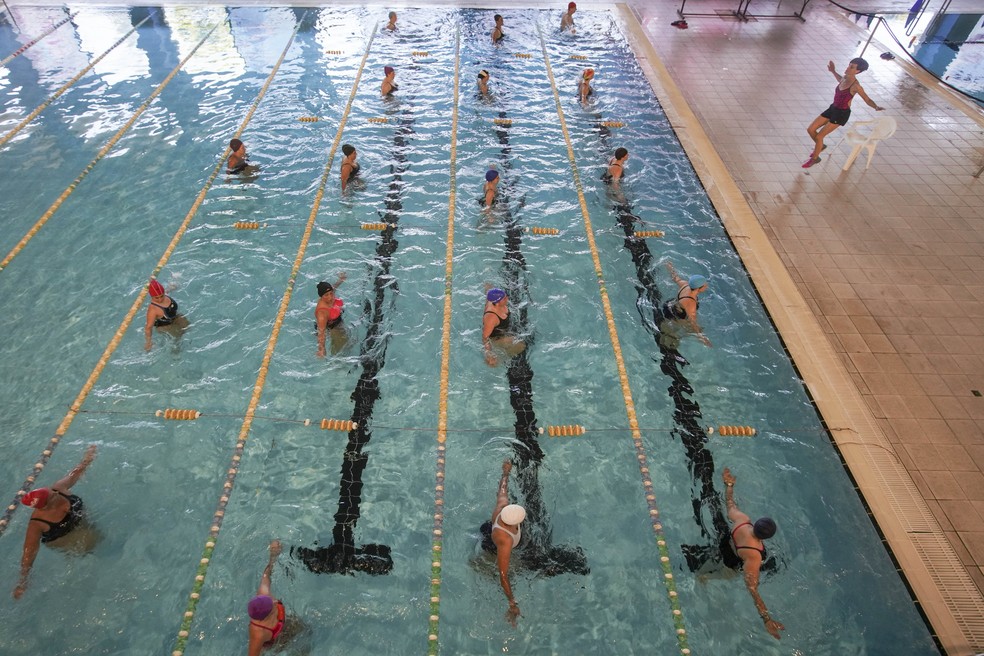 Uma aula de ginástica aquática é vista na piscina coberta de um centro esportivo em Roma, na Itália, durante sua reabertura após mais de dois meses de fechamento para impedir a propagação do coronavírus — Foto: Andrew Medichini/AP