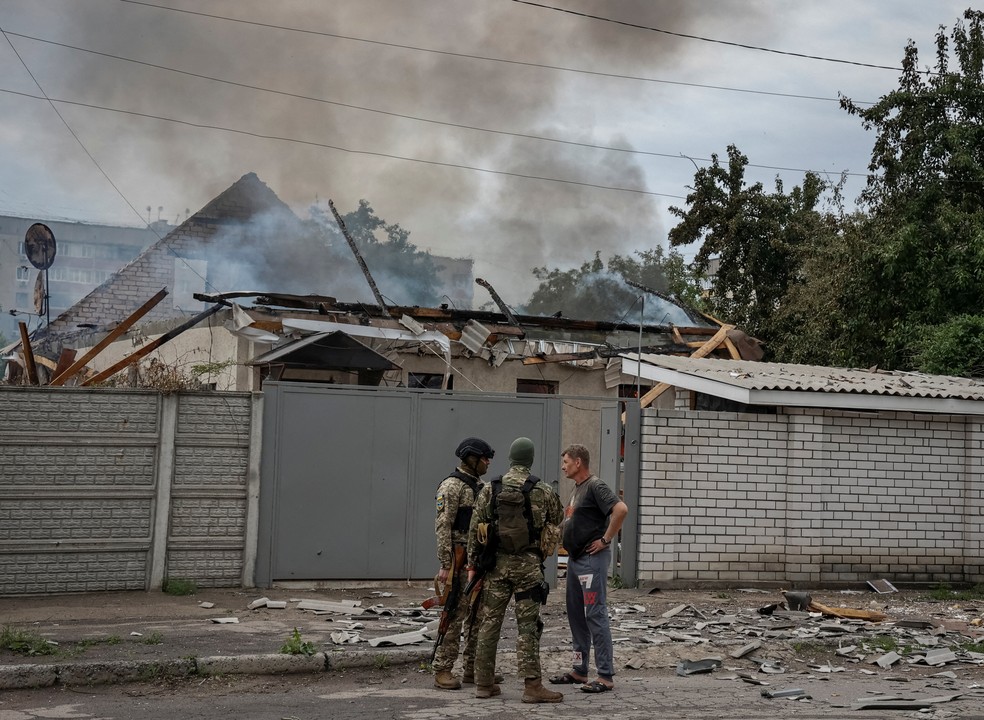 Soldados ucranianos conversam com morador que teve a casa atingida por bombardeio russo em Luhansk, no leste, parte da região onde a Rússia trava há semanas batalhas contra tropas ucranianas, em 3 de junho de 2022. — Foto: Serhii Nuzhnenk/ Reuters
