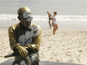 Estátua de Carlos Drummond de Andrade amanhece pichada na manhã de Natal na Praia de Copacabana, na Zona Sul do Rio de Janeiro. (Foto: Marcelo Carnaval/Agência O Globo)