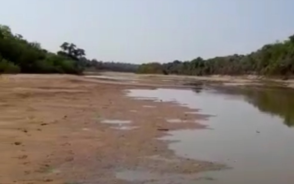 Imagem que mostra o Rio do Peixo muito seco em ponto que moradores podem atravessar à pé, em Aruanã — Foto: Reprodução/Dema