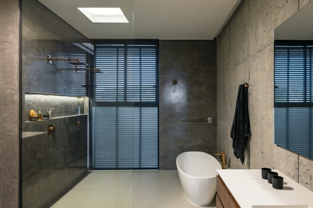 Banheiro. Com revestimento da Cement Design, tem tons sóbrios e metais dourados (Foto: Leonardo Finotti / Editora Globo)