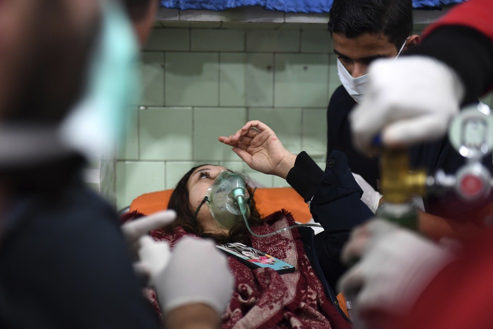 Mulher síria recebe tratamento em um hospital controlado pelo regime de Aleppo, neste sábado (24) — Foto: GEORGE OURFALIAN / AFP