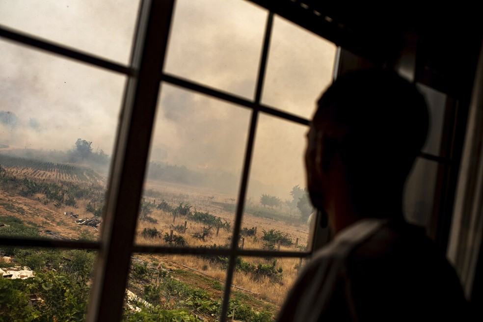 Homem observa fumaça sobre plantações de uva e azeite de oliva, no nordeste da Espanha, em 19 de julho de 2022. — Foto: AP