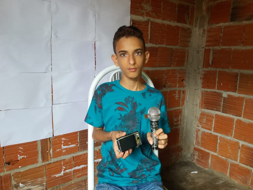 Jovem prega folhas brancas na parede para fazer suas gravaÃ§Ãµes â€” Foto: Wandenberg BelÃ©m