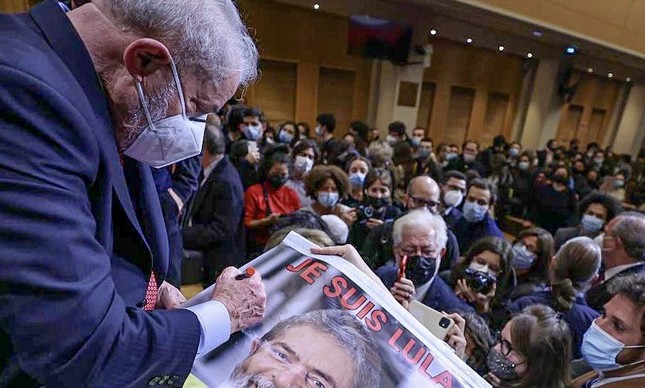 O ex-presidente Lula autografa cartaz na Sciences Po, em Paris