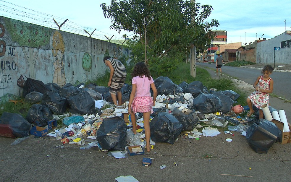 Crianças reviram lixo descartado em frente a escola em Ceilândia, no DF, em busca de materiais novos (Foto: TV Globo/Reprodução)