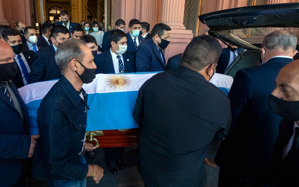 Caixão de Diego Maradona, coberto por bandeira da Argentina, é colocado em carro que o transportaria até o cemitério Jardim da Paz, em Vella Vista, na quinta-feira (26) — Foto: Esteban Collazo/Argentina's Presidency Press Office/AFP 