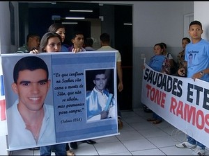 Família segurava faixa e cartaz em homenagem a vítima (Foto: Reprodução/TV Anhanguera)