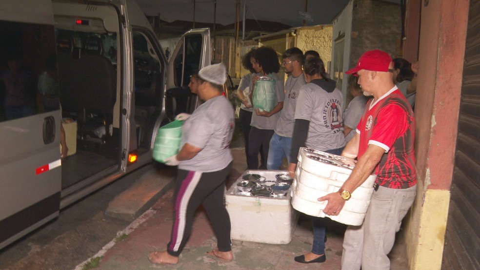 Voluntários do Projeto Fazer o Bem carregam van emprestada para entregar marmitas a pessoas em situação de rua no Centro de SP — Foto: Reprodução/TV Globo