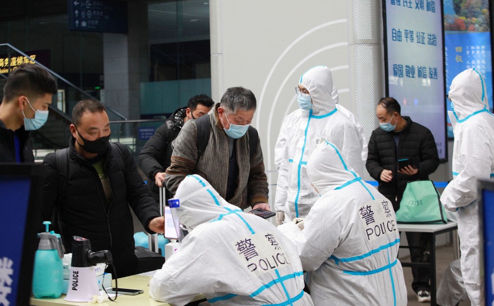 Policiais usando roupas de proteção contra Covid-19 inspecionam as informações de saúde de pessoas na Estação Ferroviária de Nanjing, na província de Jiangsu, em 17 de janeiro de 2022 na China — Foto: China Daily via Reuters