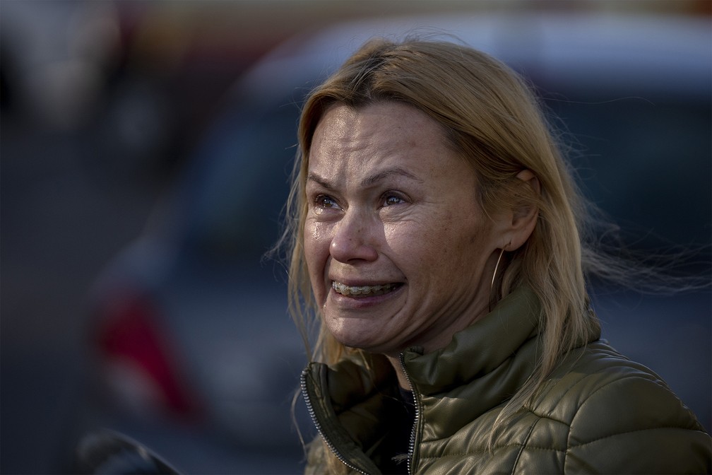 26 de fevereiro - Uma mulher reage olhando para prédio danificado após ataque em Kiev, Ucrânia — Foto: Emilio Morenatti/AP