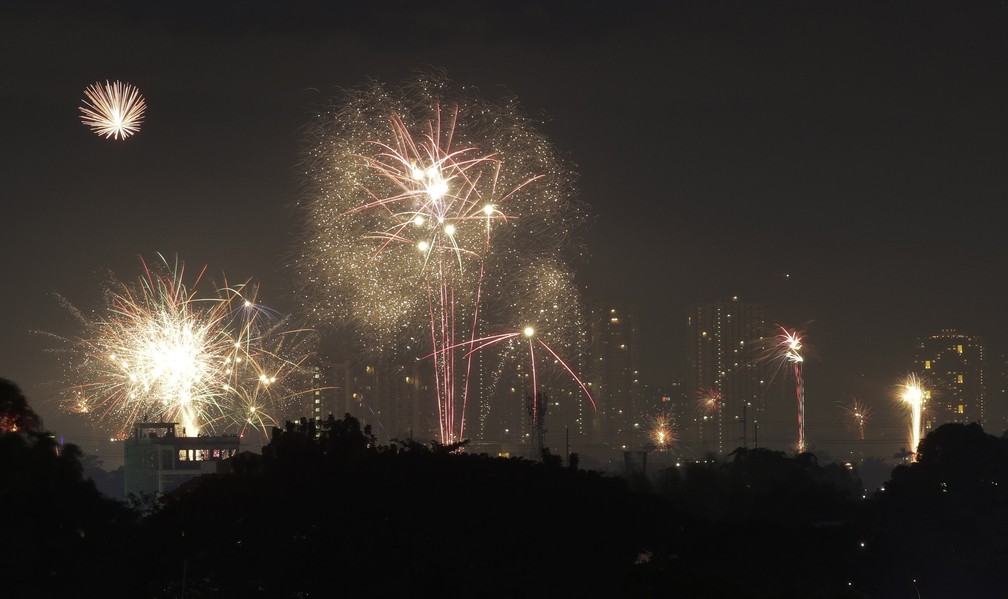 Fogos de artifício iluminam o céu durante as moderadas celebrações de Ano Novo, na cidade de Quezon, nas Filipinas — Foto: Aaron Favila/AP