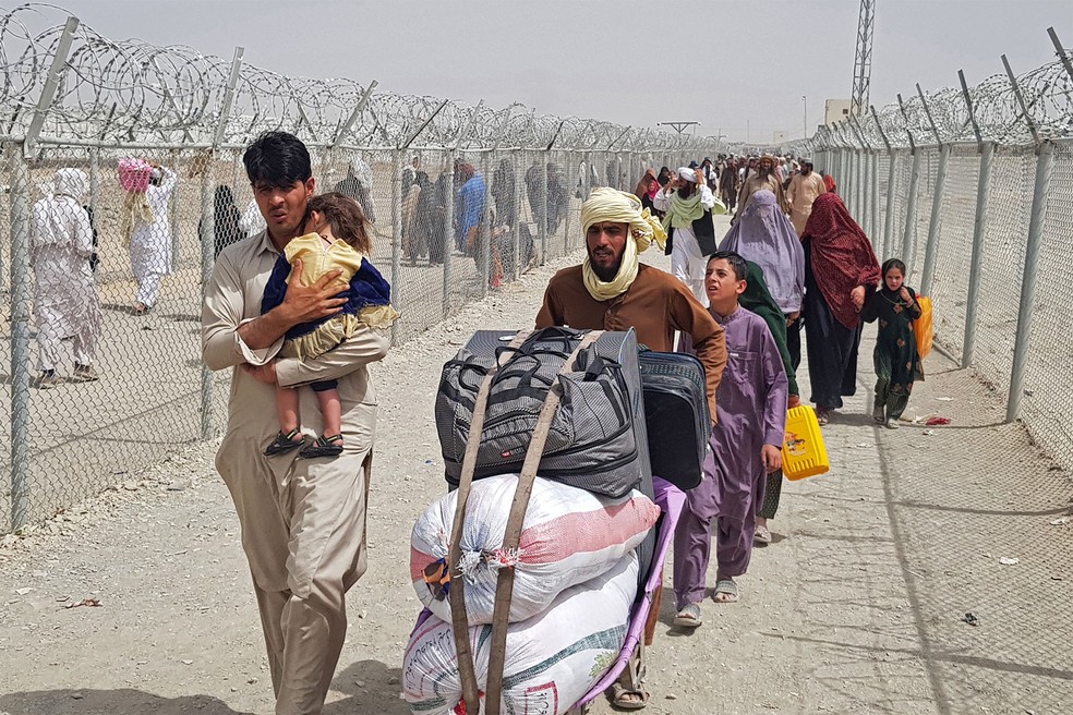 Afegãos chegam ao ponto de travessia de Chaman, no Paquistão, para retornar ao seu país nesta segunda (16), após o Talibã assumir o controle de Cabul — Foto: AFP