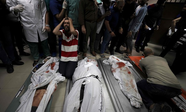 Parentes com corpos de crianças mortas por ataque israelense em um campo de refugiados na Faixa de Gaza