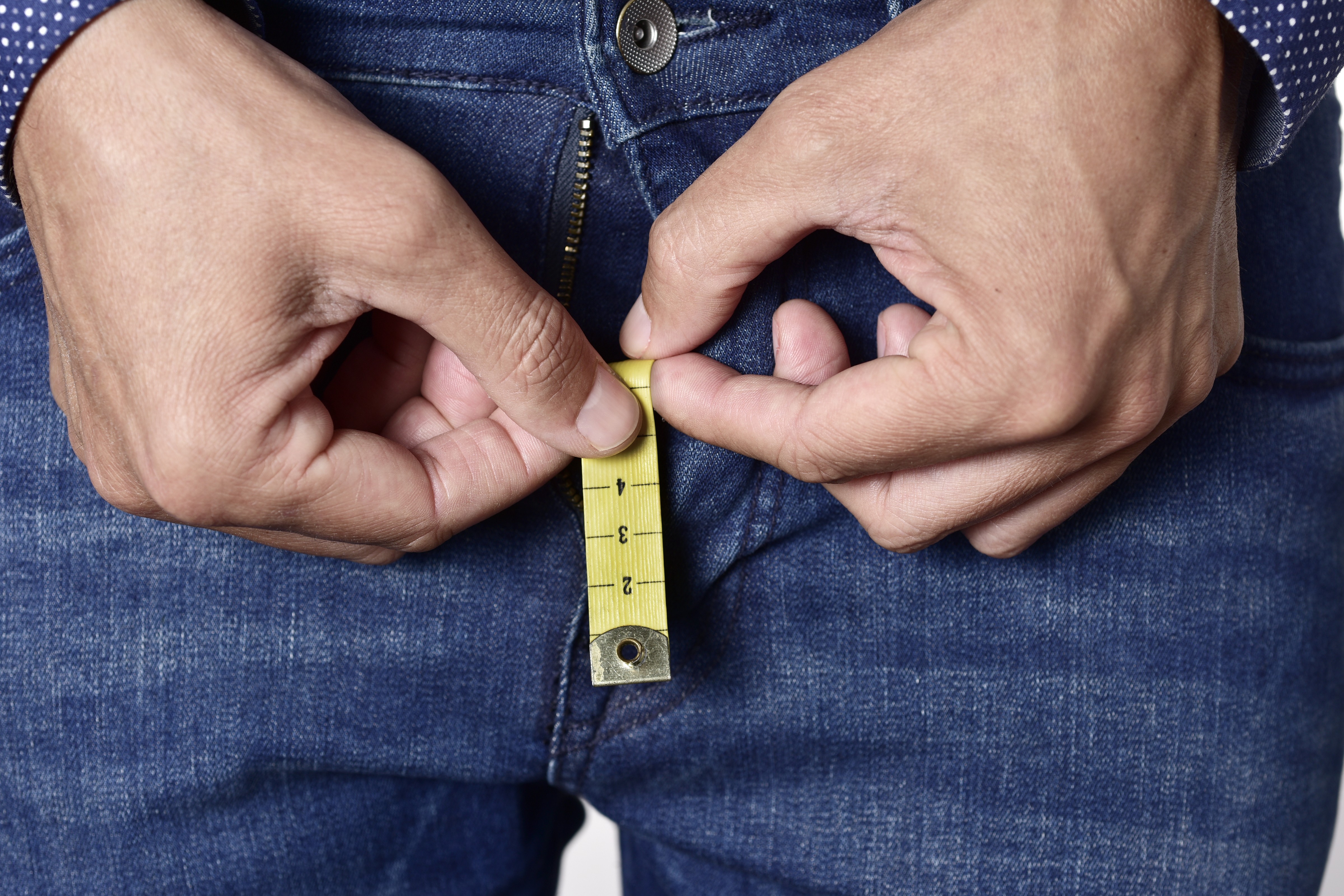 Homem segura fita métrica que sai da braguilha de sua calça (Foto: Getty Images)