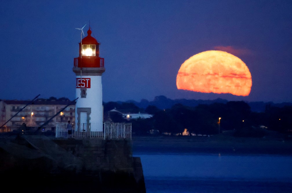 Superlua dos Cervos é vista atrás de um farol em Saint-Nazaire, na França — Foto: Reuters