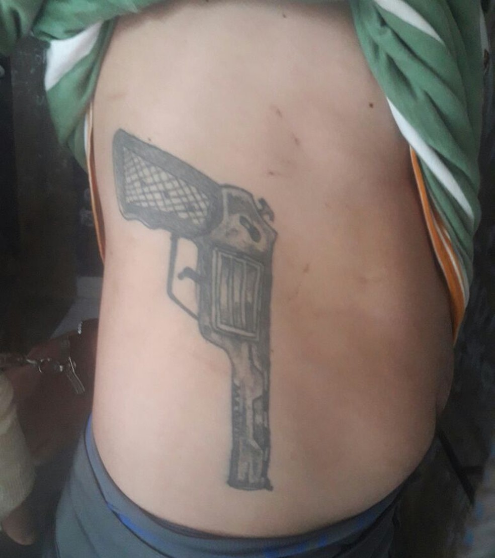 Tatuagem de arma fica na lateral do corpo do suspeito (Foto: Divulgação/Polícia Civil)