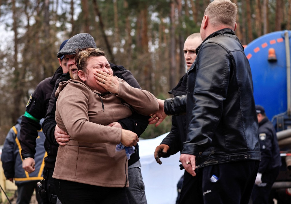 Mãe chora ao reconhecer o corpo do filho em Buzova, na região de Kiev. Segundo o chefe da administração local, ele teria sido mortos por soldados russos