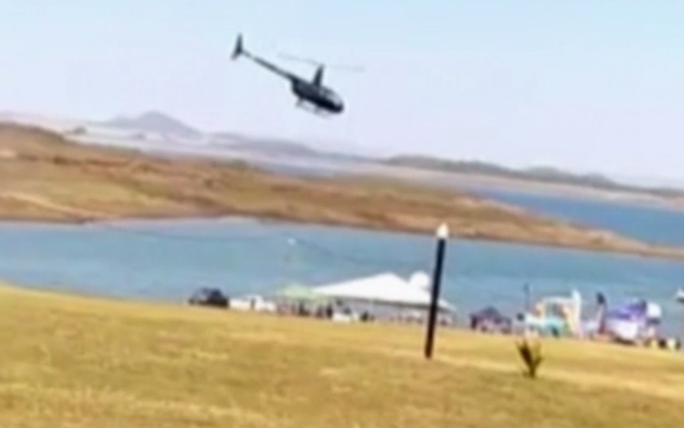 Helicóptero que caiu é registrado em vídeo sobrevoando Lago das Brisas, em Buriti Alegre — Foto: Reprodução/TV Anhanguera
