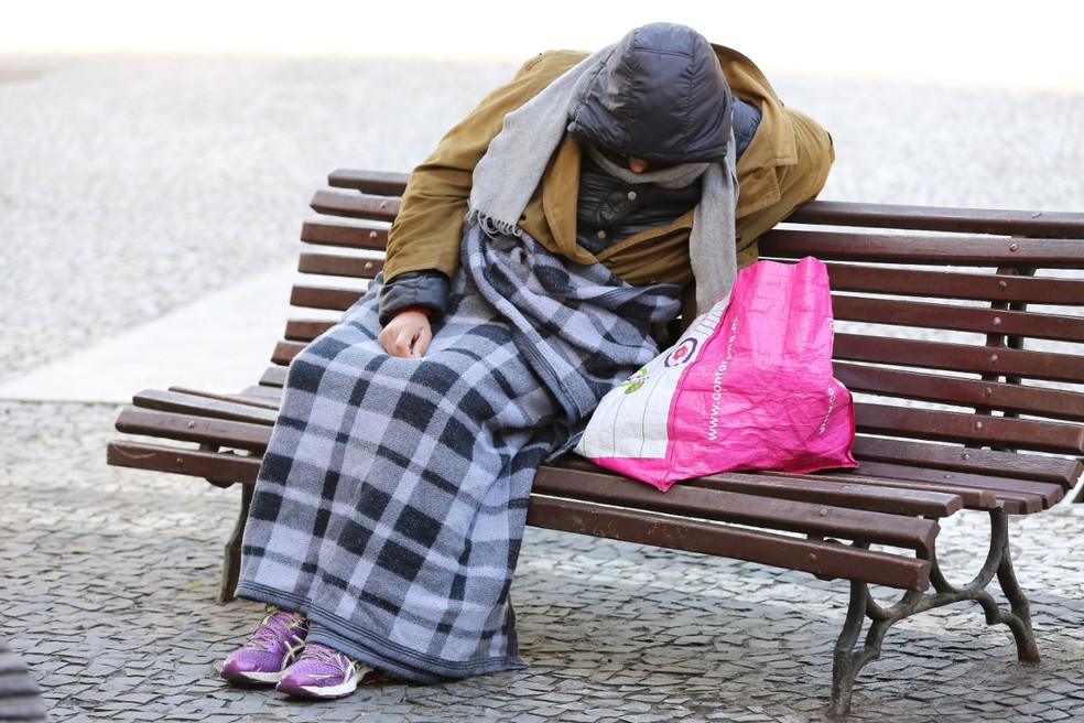 Morador de rua se agasalha com cobertor — Foto: Giuliano Gomes