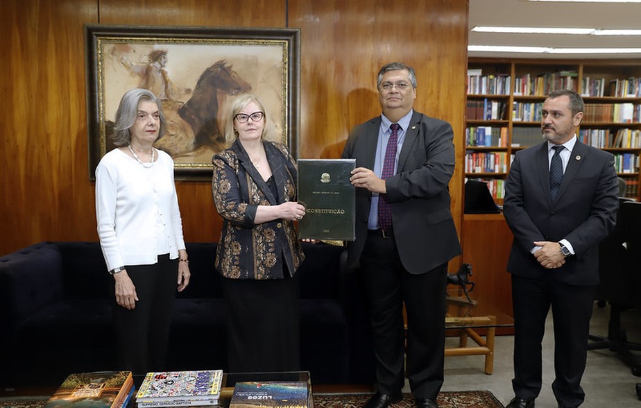 O ministro da Justiça, Flávio Dino, entrega à presidente do STF, Rosa Weber, cópia da Constituição que foi tirada da Corte