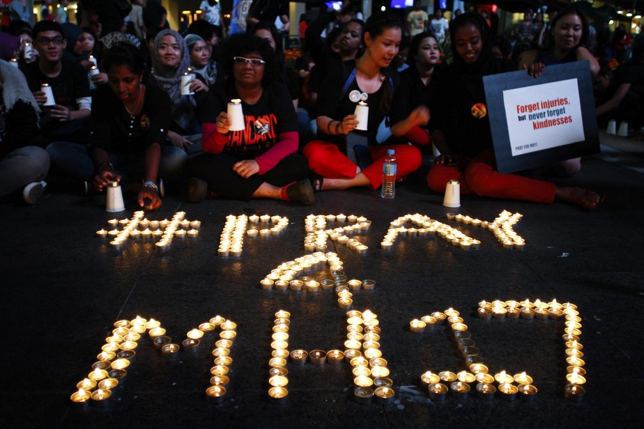 Ativistas acendem velas como parte de vigília para o voo 17 da Malaysian Airlines em Kuala Lumpur, Malásia