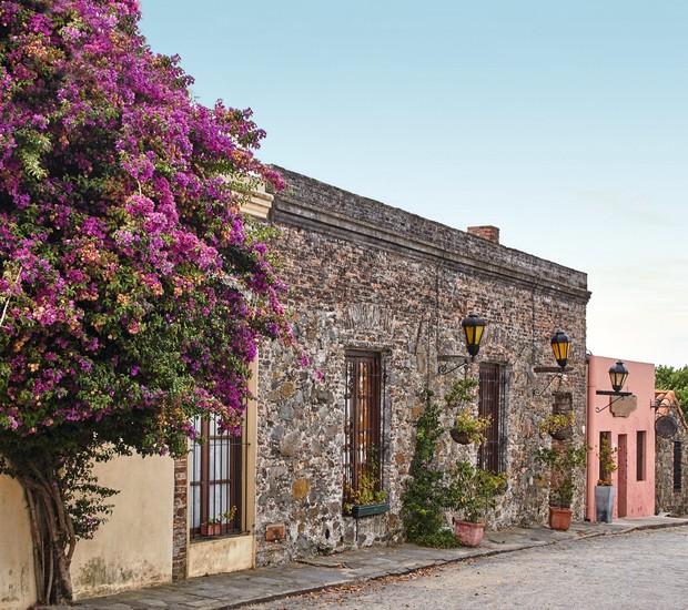 Casa de pedra, caminho de pedra, flores e charme às margens do Rio da Prata: Colonia del Sacramento, no Uruguai, foi colonizada por portugueses e é patrimônio da Unesco (Foto: Thinkstock)