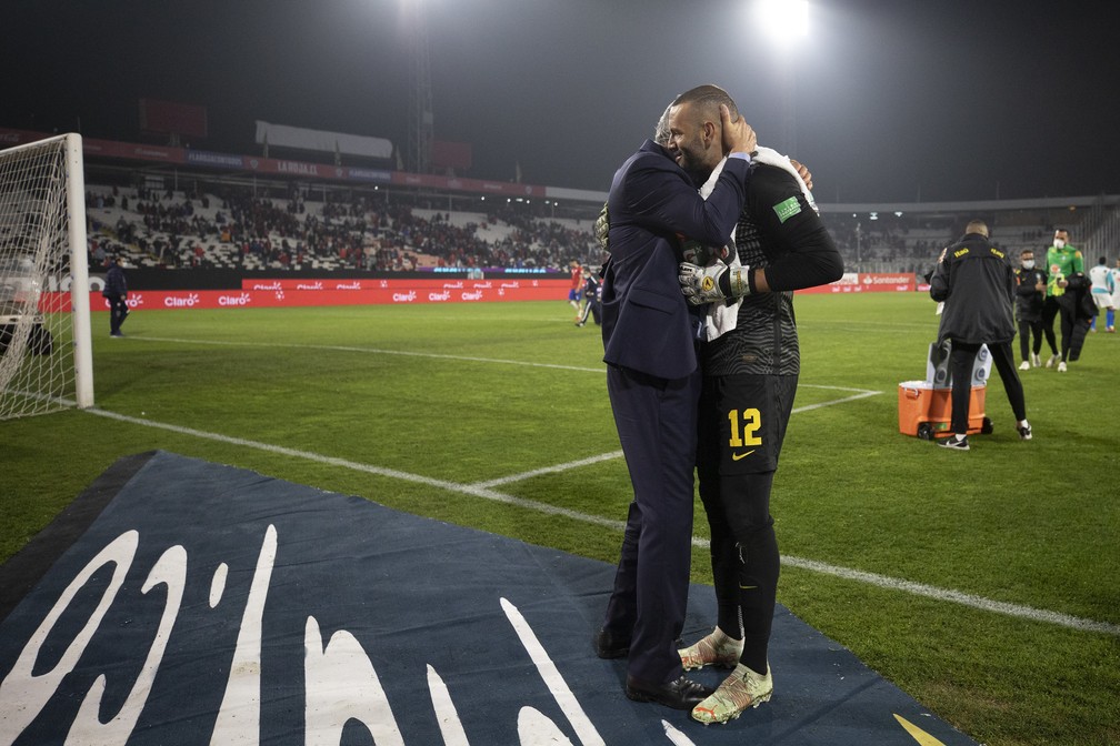 Goleiro Weverton é abraçado por Tite após vitória da Seleção: Brasil venceu em jogo de muitas dificuldades em Santiago — Foto: Lucas Figueiredo / CBF