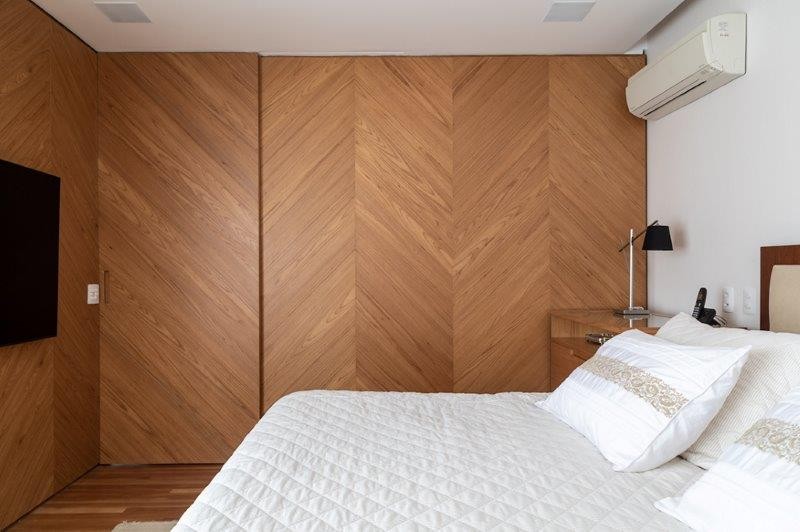 QUARTO | A madeira mimetiza a entrada do quarto e é usada também na cabeceira (Foto: Divulgação / Evelyn Müller)