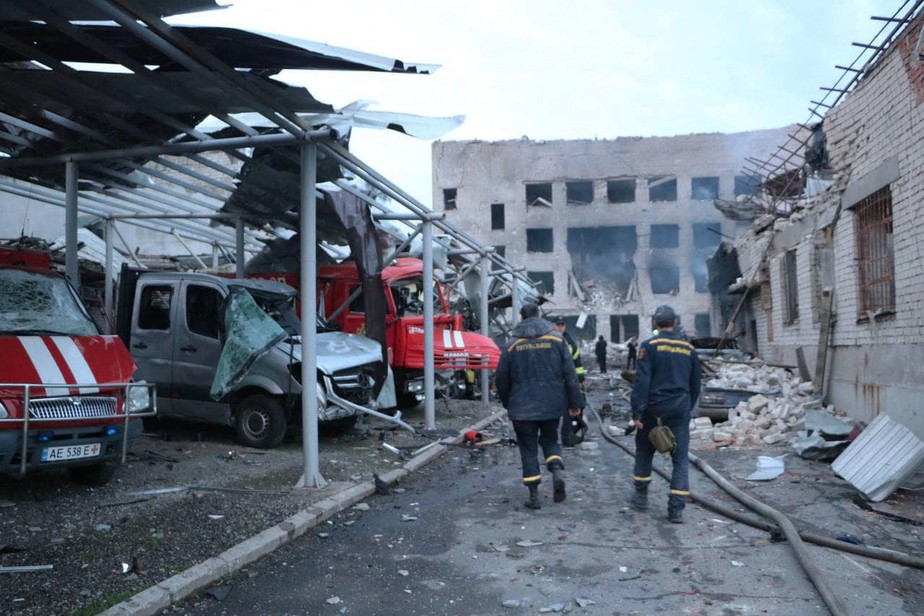 Equipes de resgate observem o que restou do ataque de drones russos a um quartel de bombeiros em Dnipro