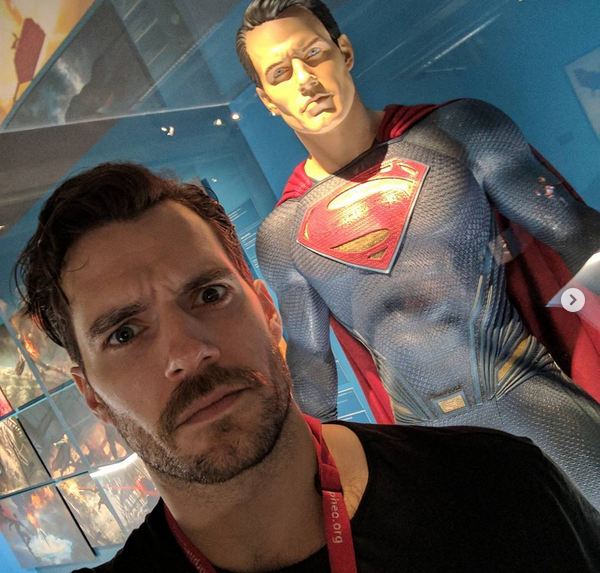 O ator Henry Cavill de bigode em frente a uma estátua do Super-Homem (Foto: Instagram)