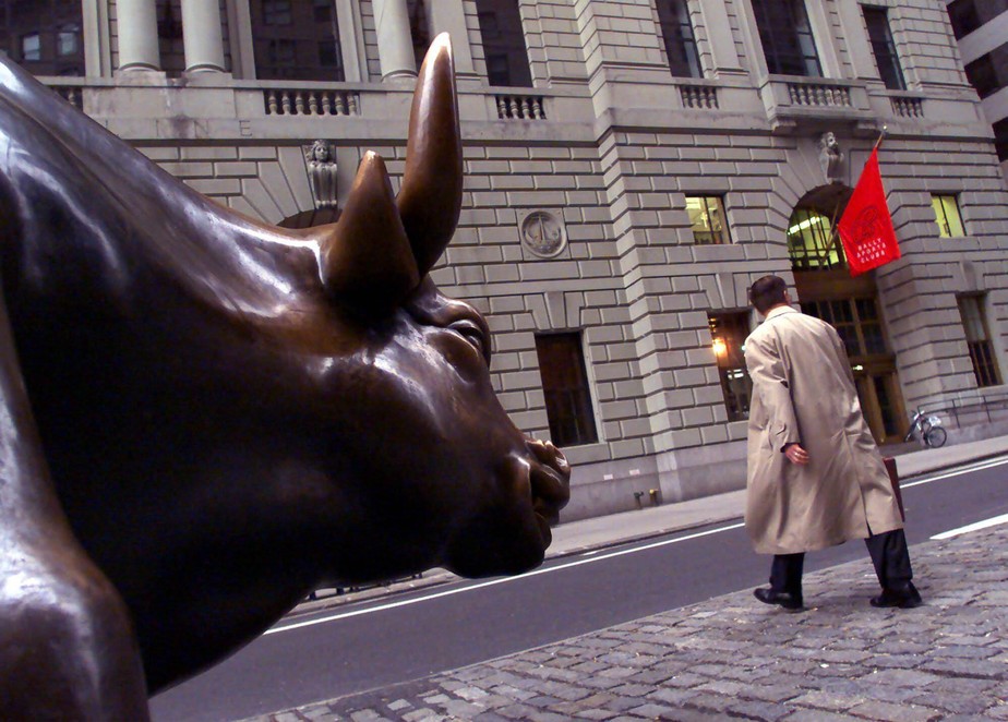 A Wall Street worker walks in front of the bull statue on lower Broadway in New York's financial district before the financial markets opened  Monday morning, April 17, 2000. The Dow Jones industrials